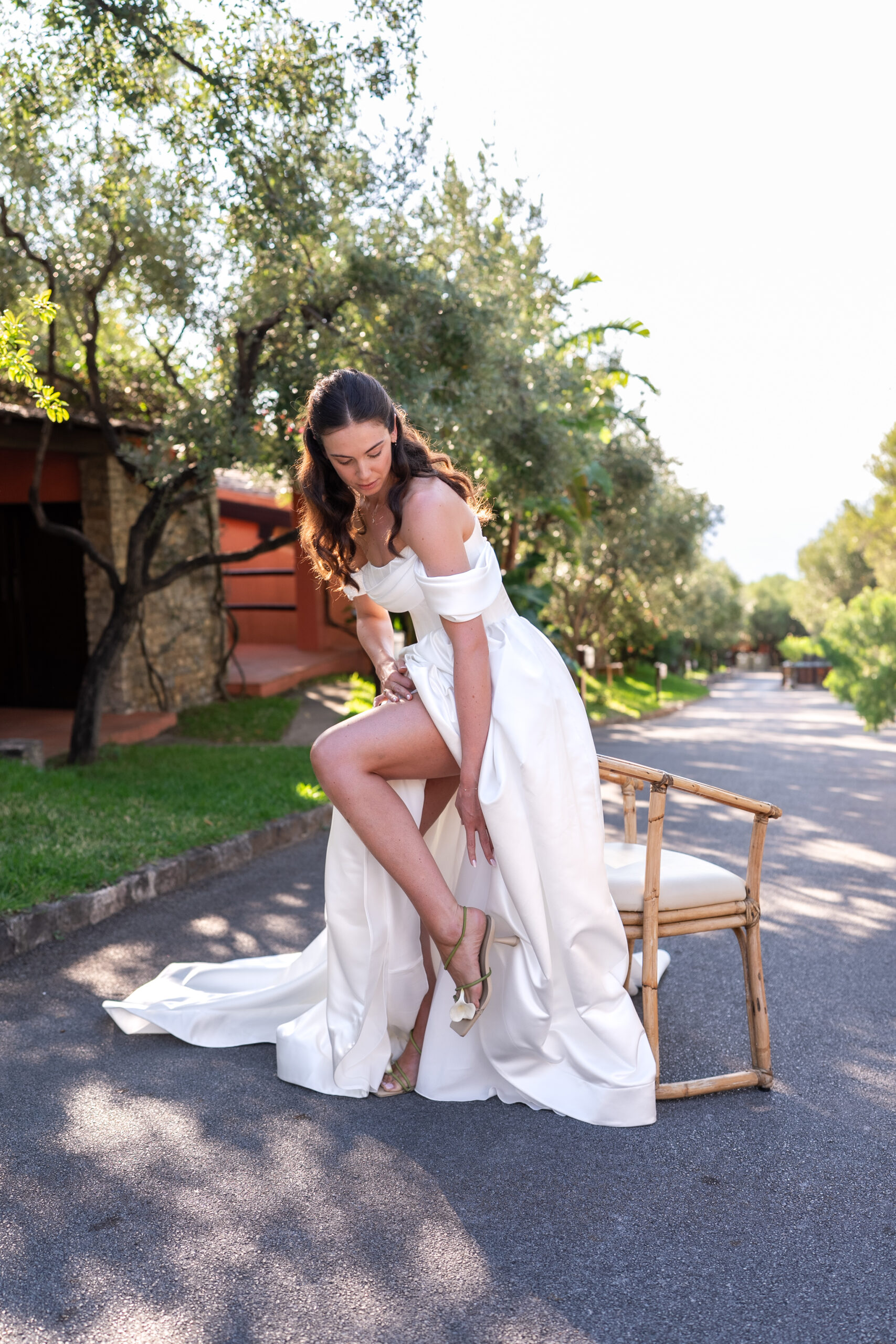 Morane adjusting her wedding shoes before the ceremony