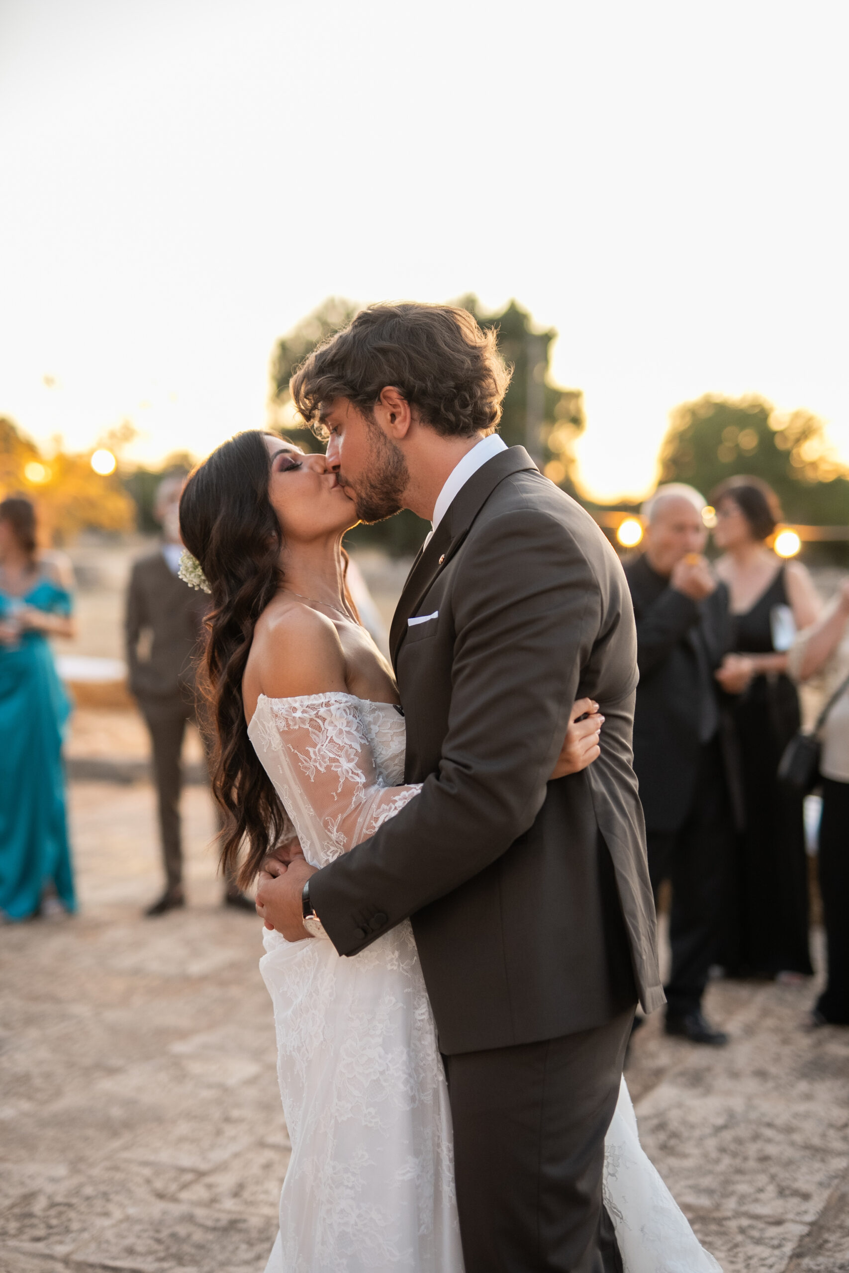 Close embrace between Angel and Andrea, with sunlight falling across Angel’s wedding dress.