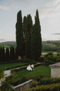 Chloe and Mike walking through the Italian garden beneath the cypress trees at Villa Fabbriche Palma.