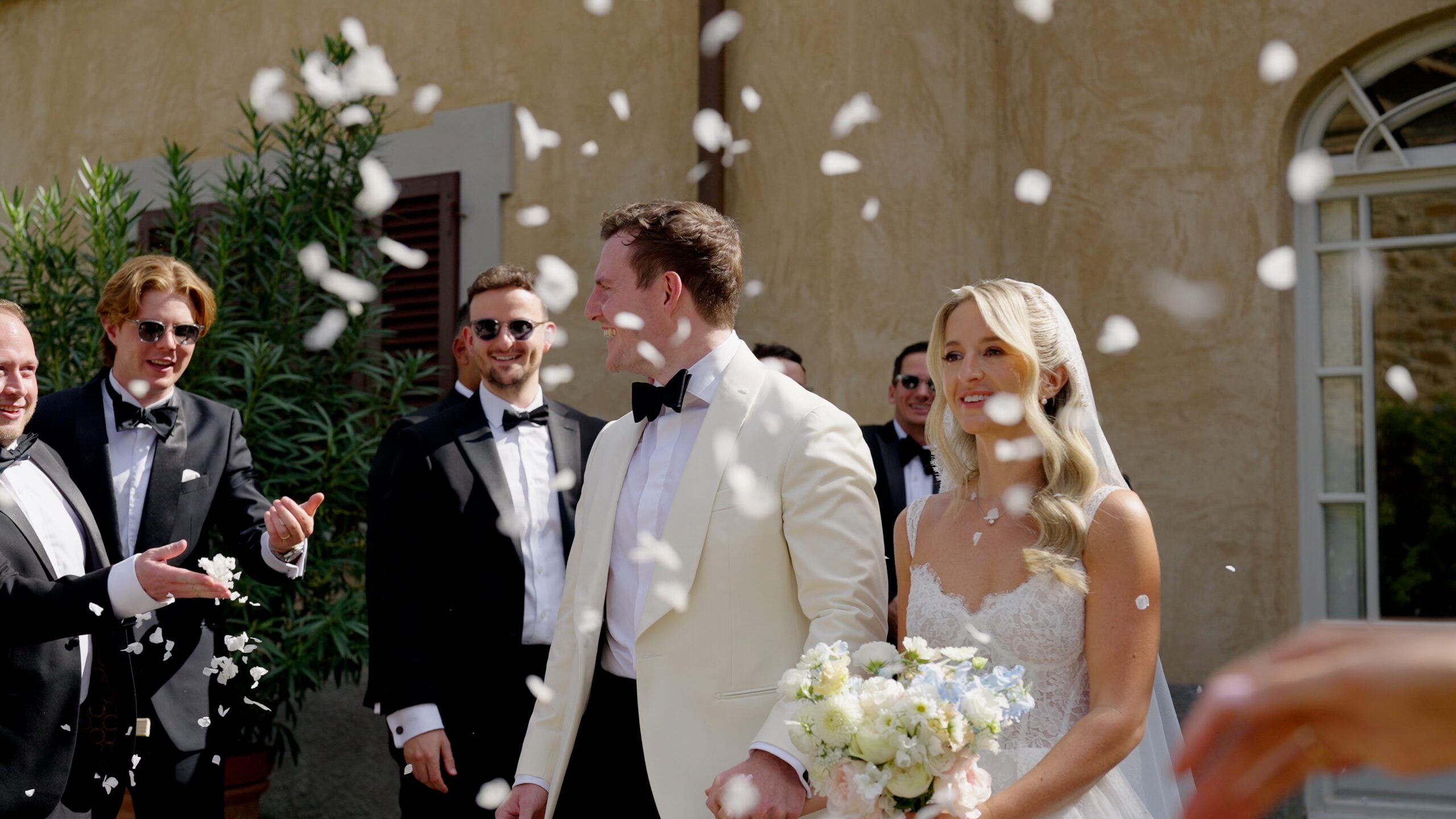 Chloe and Mike leaving their wedding ceremony as guests throw confetti at Villa Fabbriche Palma.