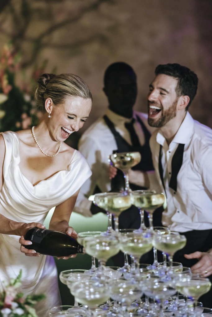 Adam and Bex pouring champagne at their Villa Grabau wedding reception
