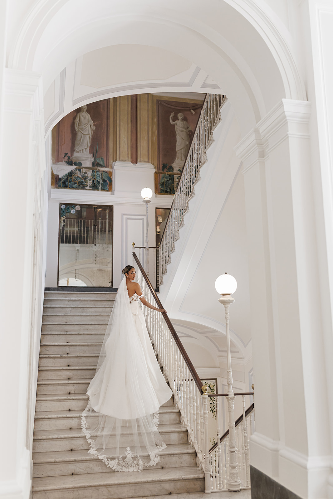 Zeenat walking down the grand staircase at Bellevue Syrene