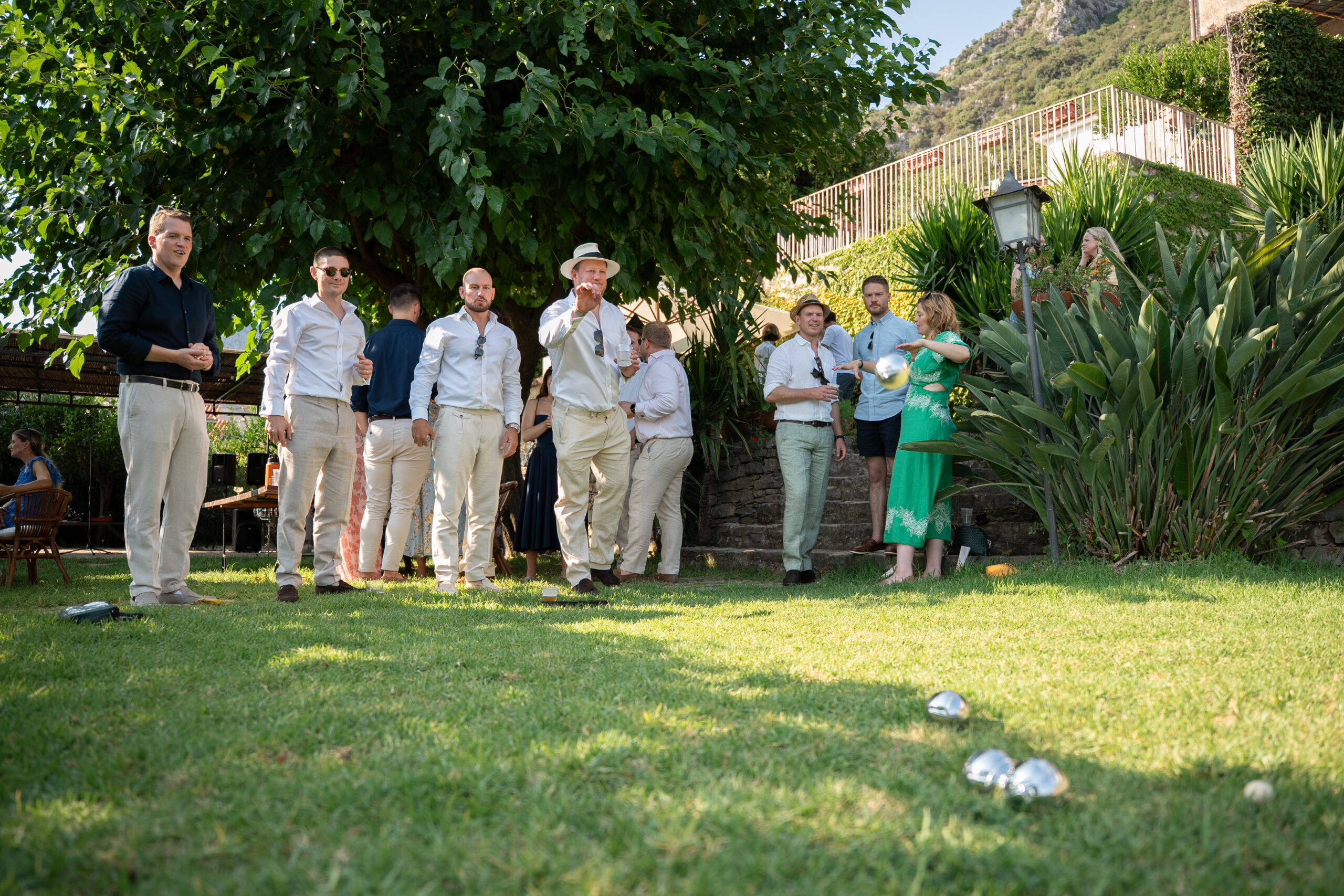 Wedding guests playing petanque in the garden at Domus Laeta