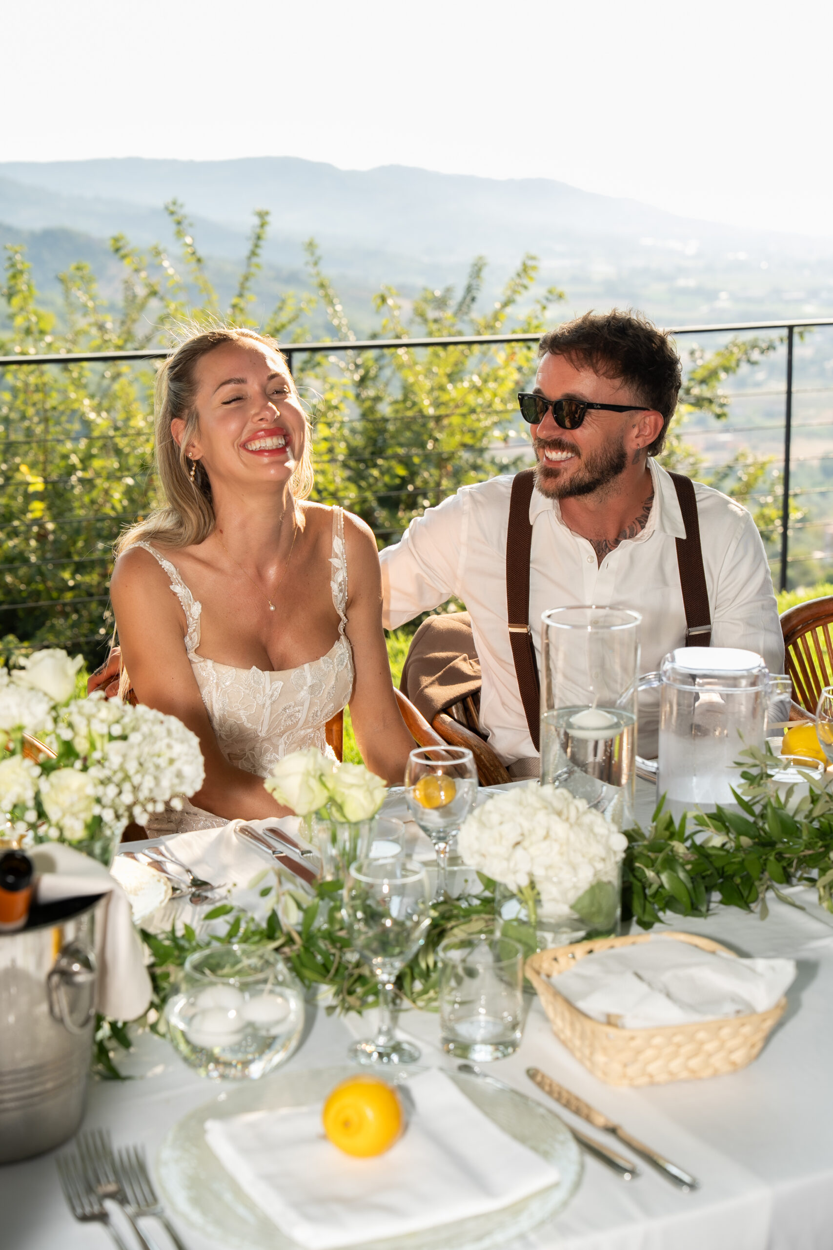 Adam and Polly laughing during their outdoor wedding dinner