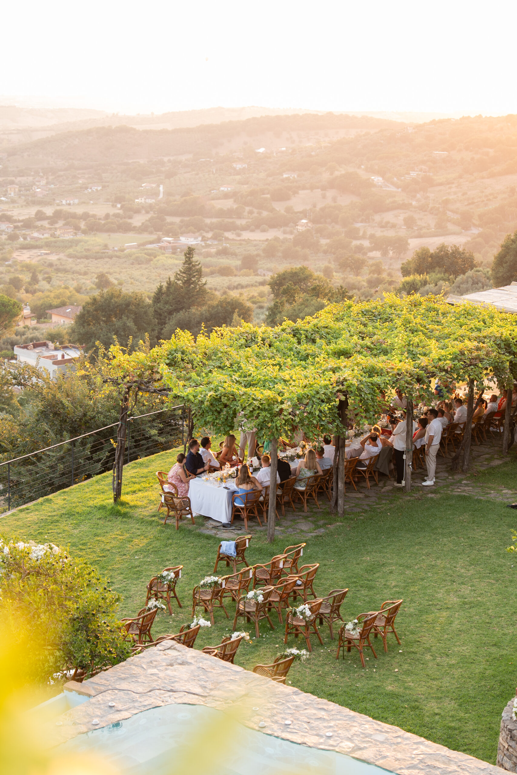 Outdoor wedding dinner beneath the vine pergola at Domus Laeta
