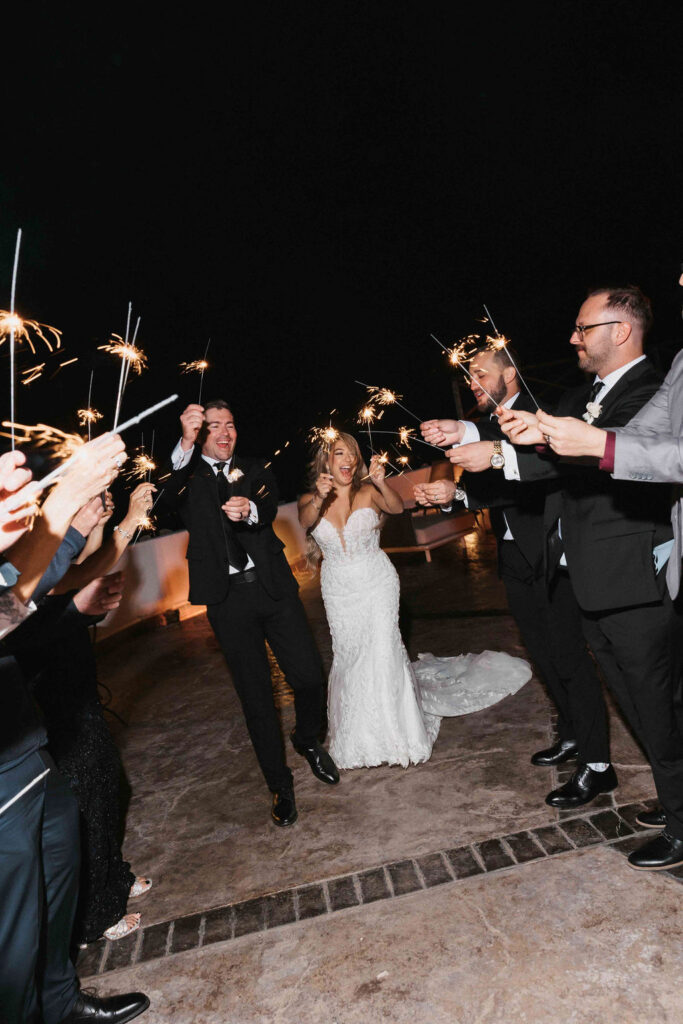 Newlyweds walking through a sparkler exit with their guests