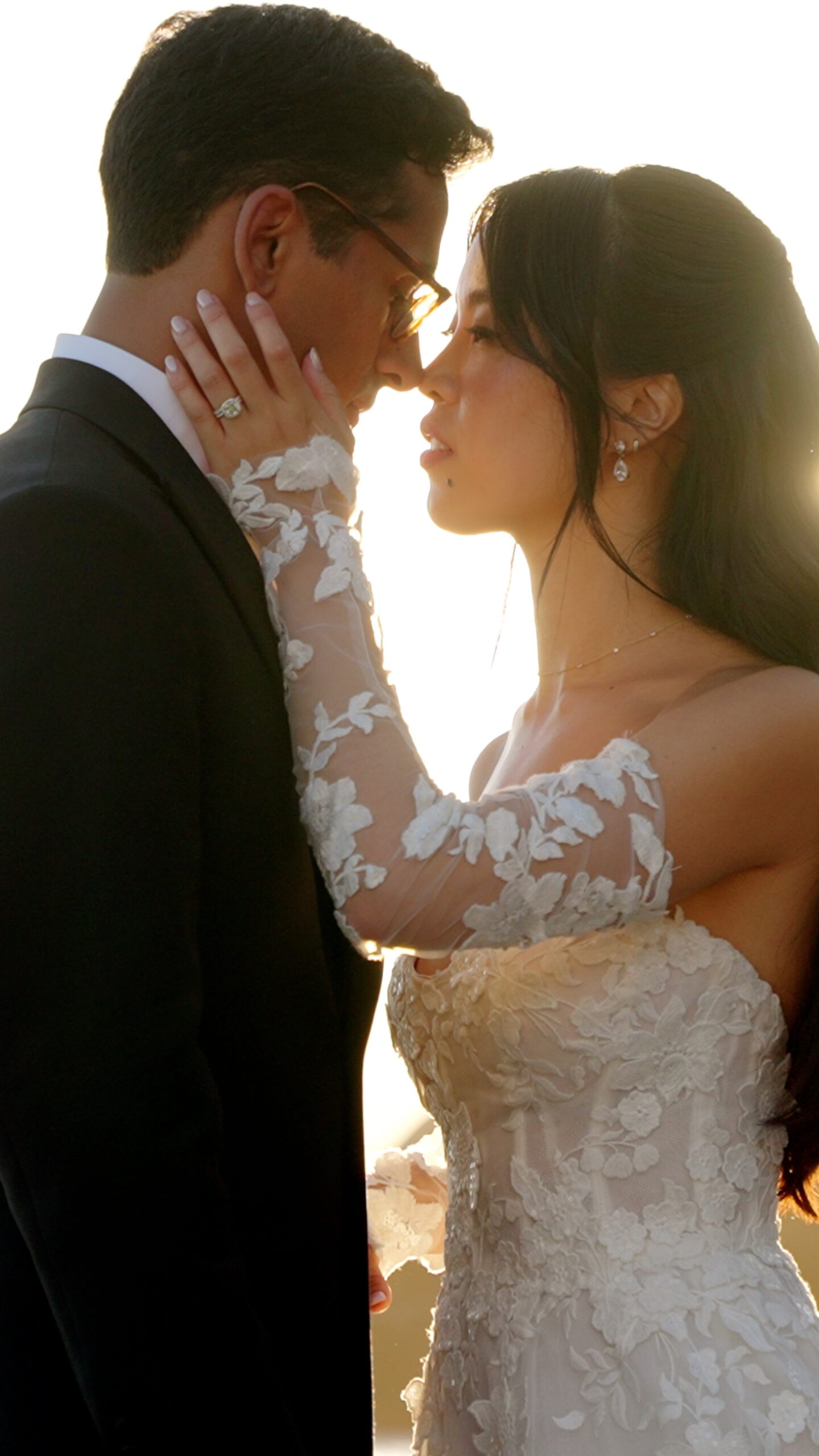 Vertical portrait of Gaia and Sheh embracing in warm evening light.