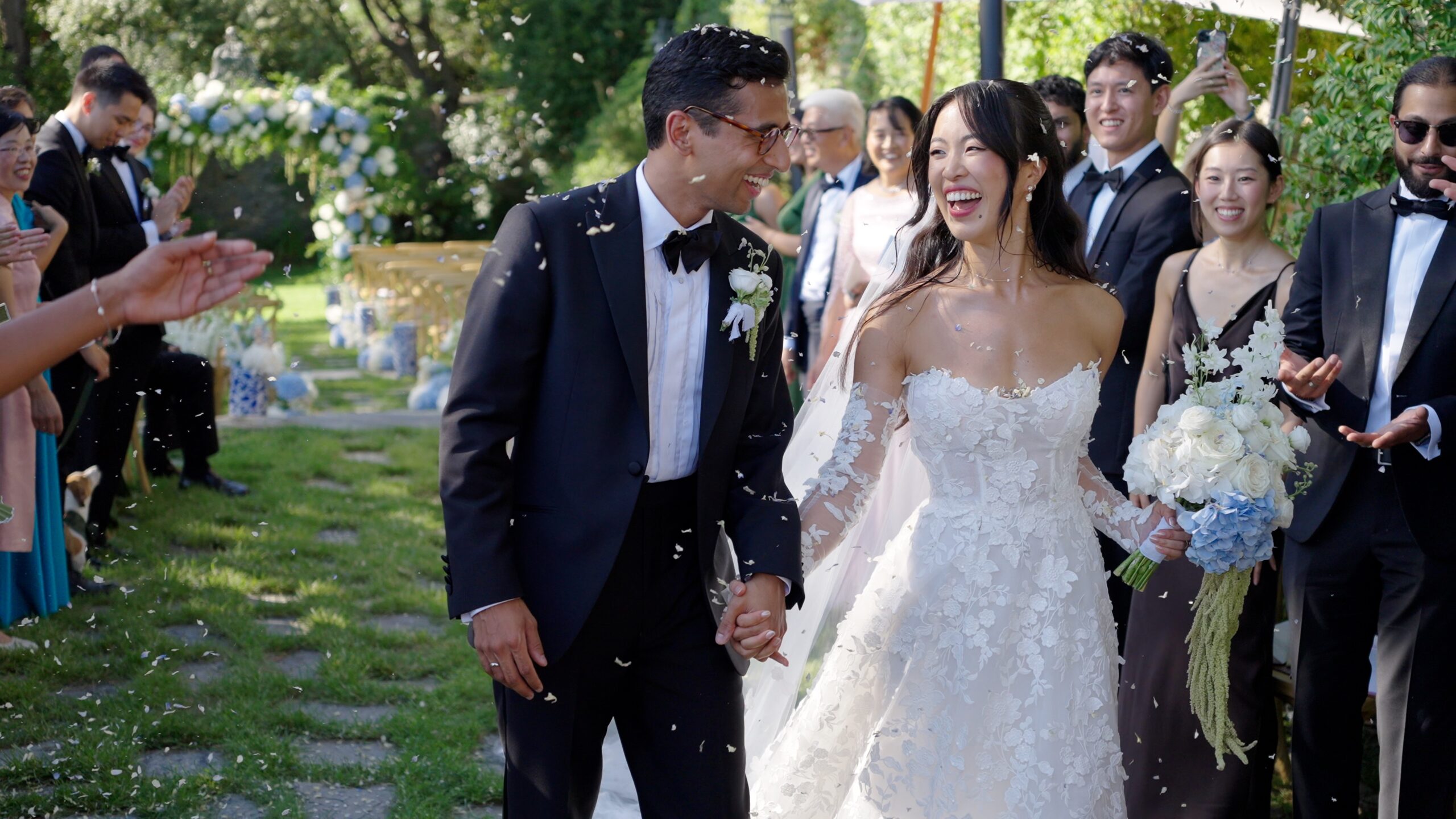 Gaia and Sheh walking through flower petals after their wedding ceremony at Castello Canevaro near Portofino