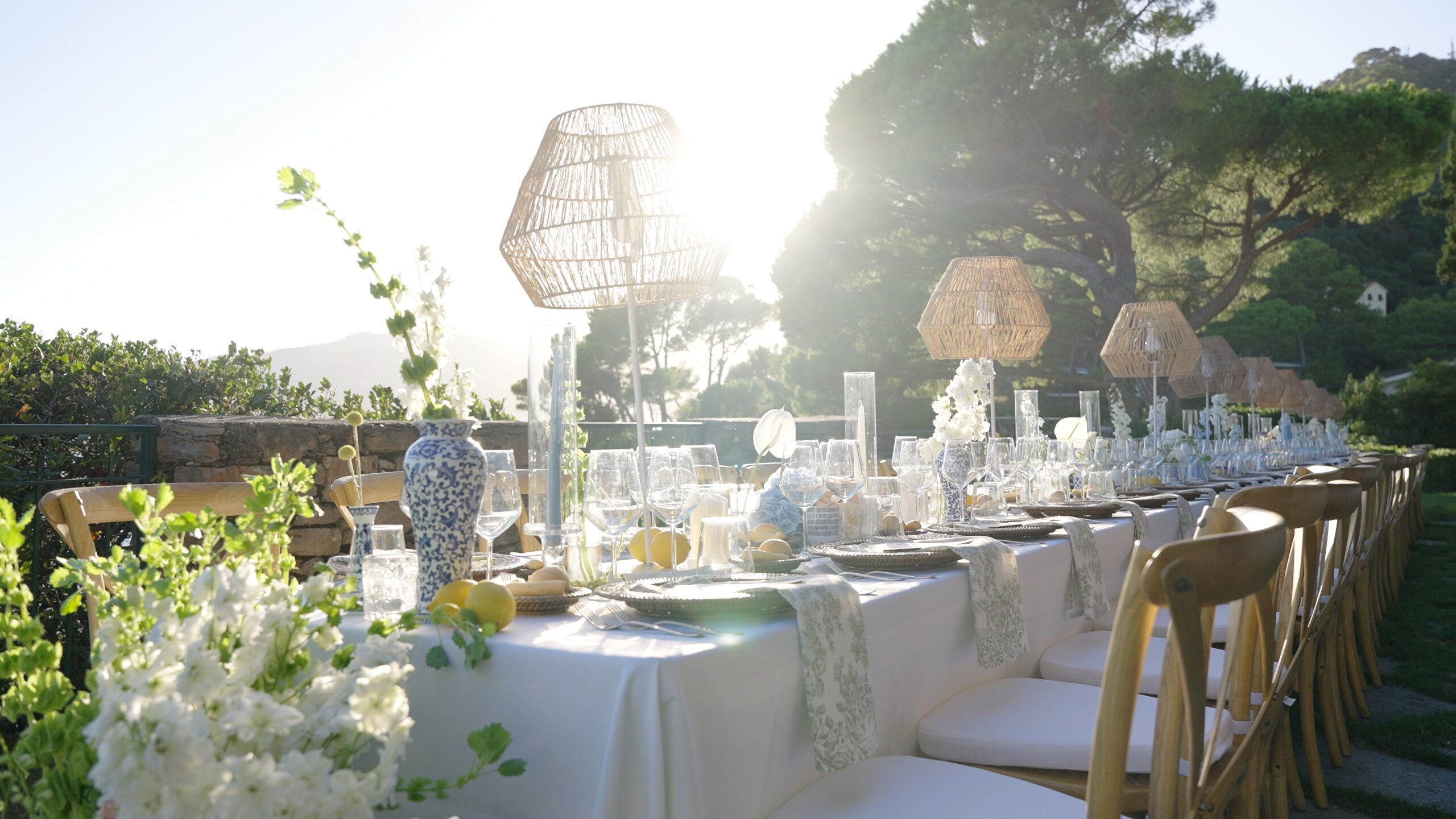 Outdoor wedding reception tables with white flowers and woven lamps at Castello Canevaro.